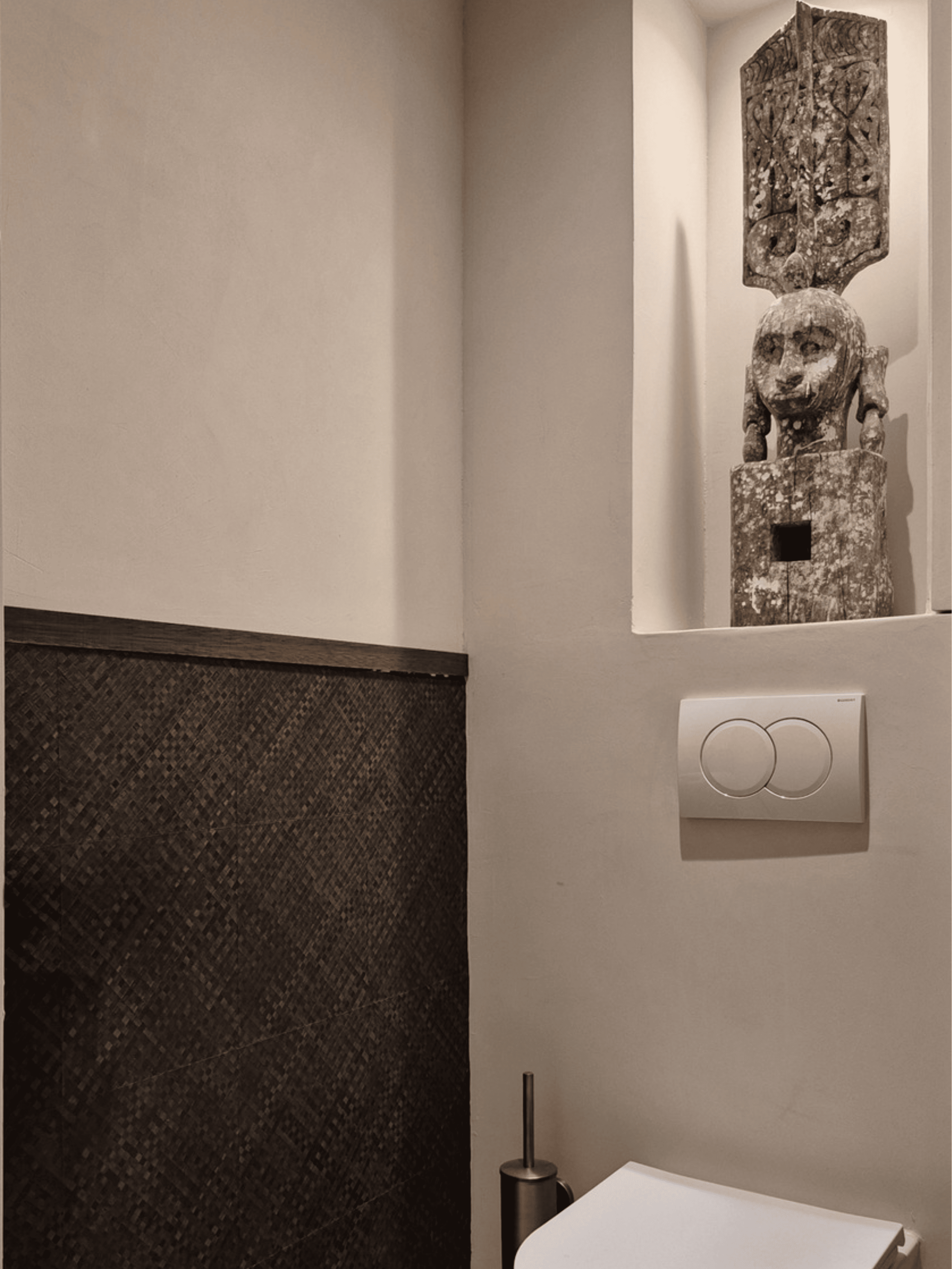 Toilet ruimte met zachte beige betonlook wandafwerking gecombineerd met donkerbruin designbehang en klassieke sierlijsten. Stijlvol contrast met warme, luxueuze en moderne interieurafwerking.