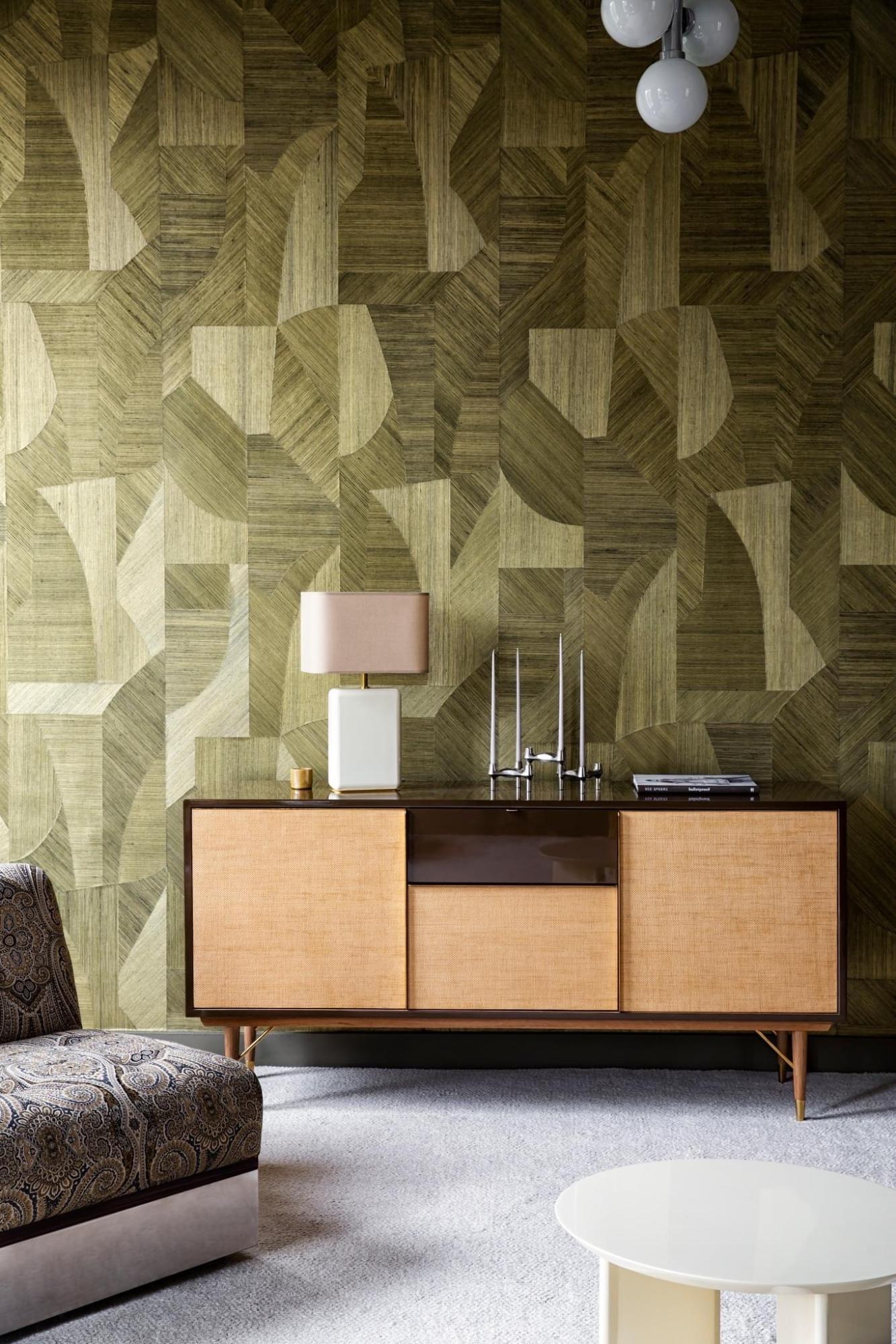 Showroom appartement RED - geometrische vormen in het groen en gewoven als muurbekleding / behang van Arte Walls. Een blauwe zetel gecombineerd met warm, licht gelig hout als dressoir en een prachtige wit-grijze tapijt