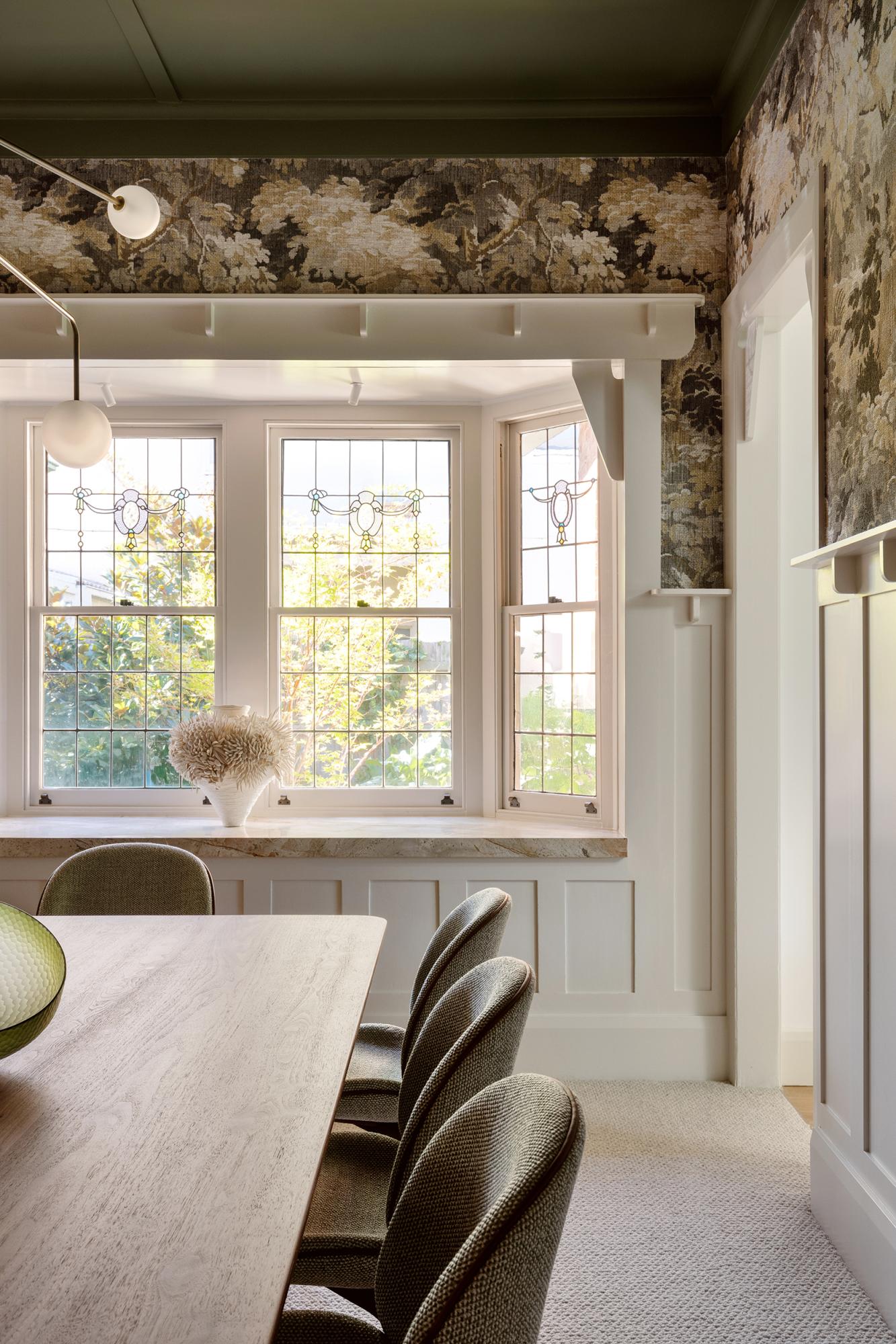 Eetkamer van Studio Esar met sierlijsten op de muren, hanglamp, witte muurverf en Arte Walls designbehang in natuurtinten. Houten tafel en stoelen gecombineerd met zachte stoffering voor een warme en stijlvolle sfeer.
