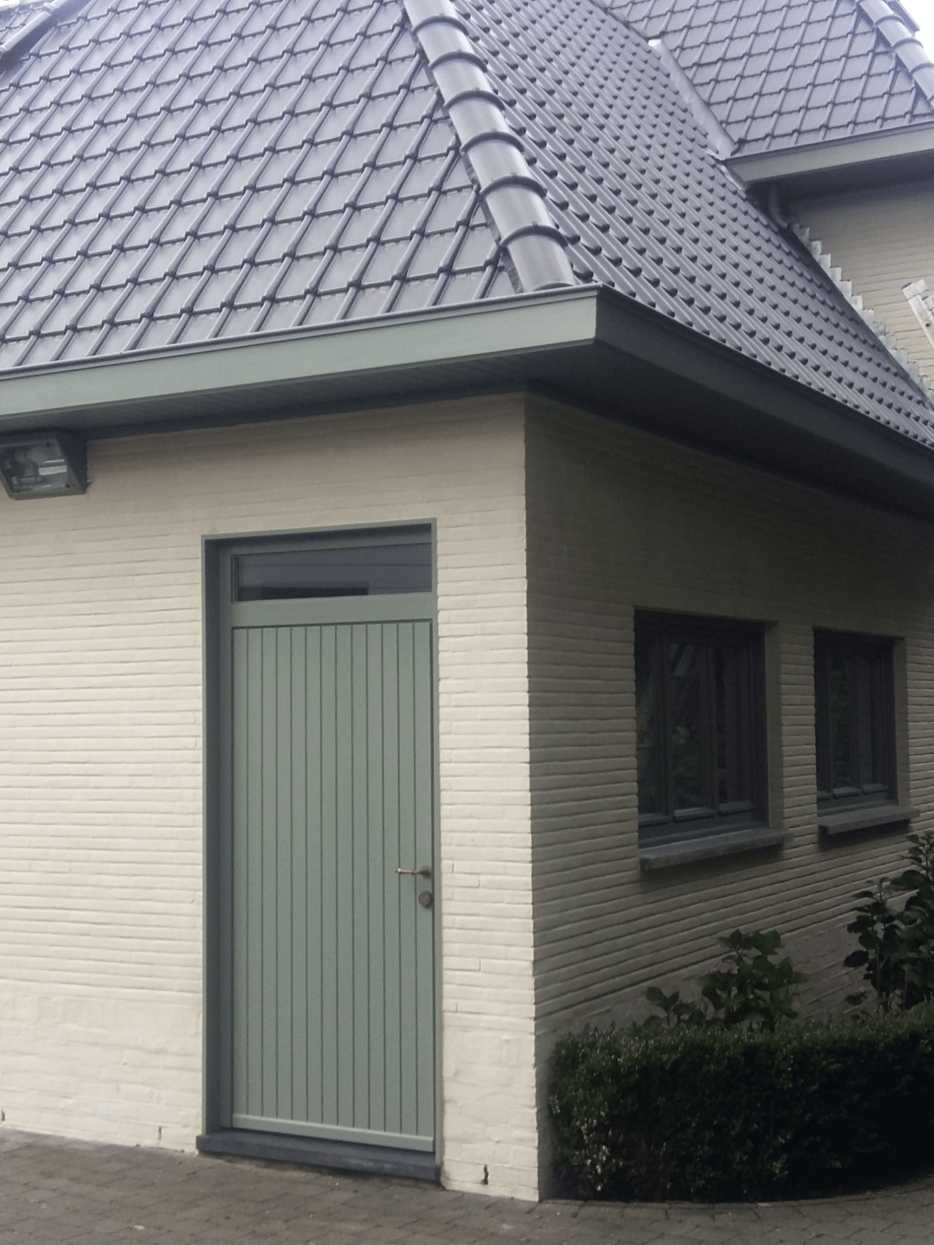 Landelijke voordeur met gekaleide gevel en bronzen wandverlichting