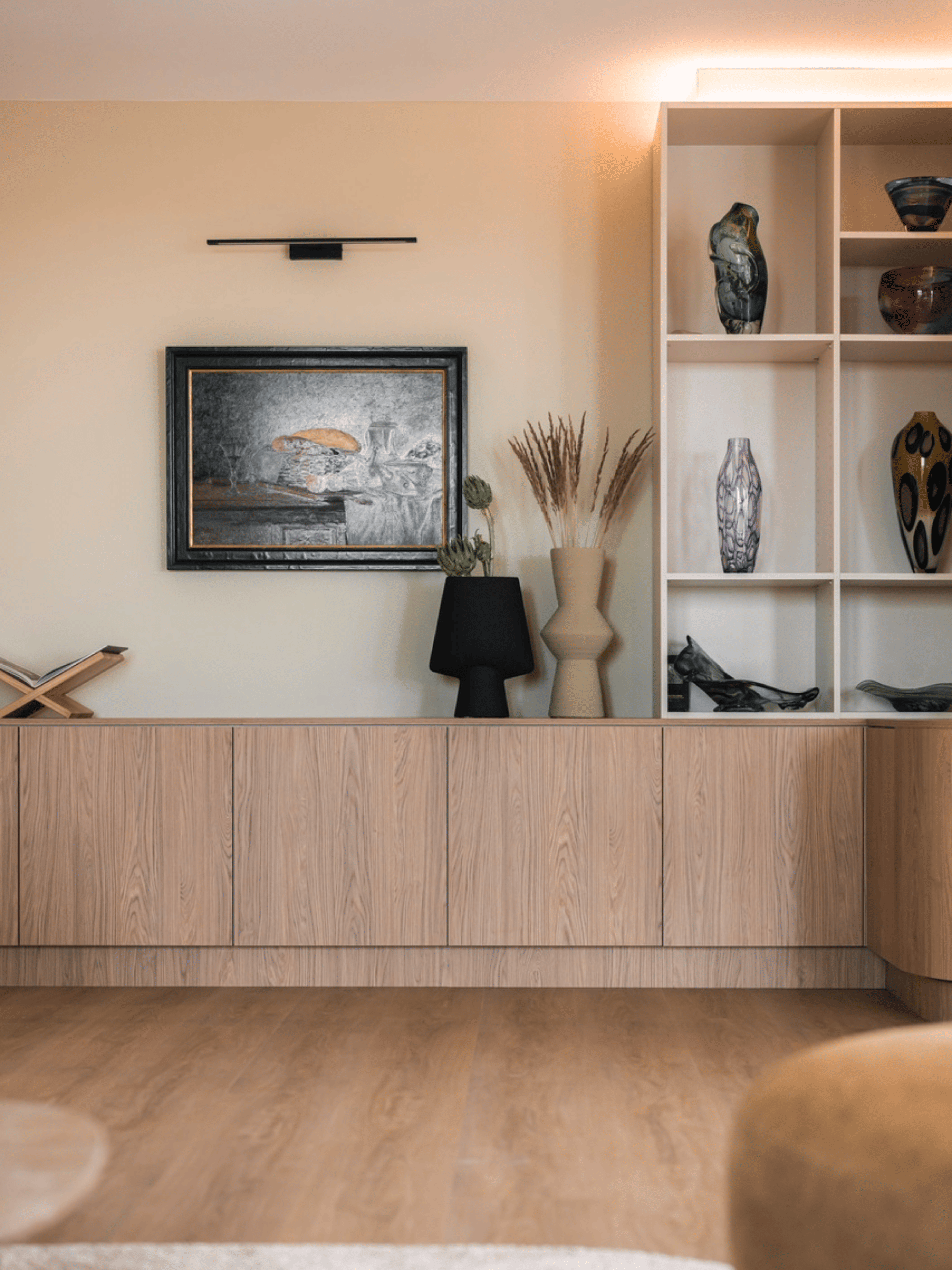 Strak landelijk interieur afgewerkt met verf van Pure & Original in zachte natuurtinten. Houten vloer zorgt voor warmte, gecombineerd met witte sierprofielen, grote schilderijen als eyecatcher en groene planten voor een natuurlijke uitstraling.