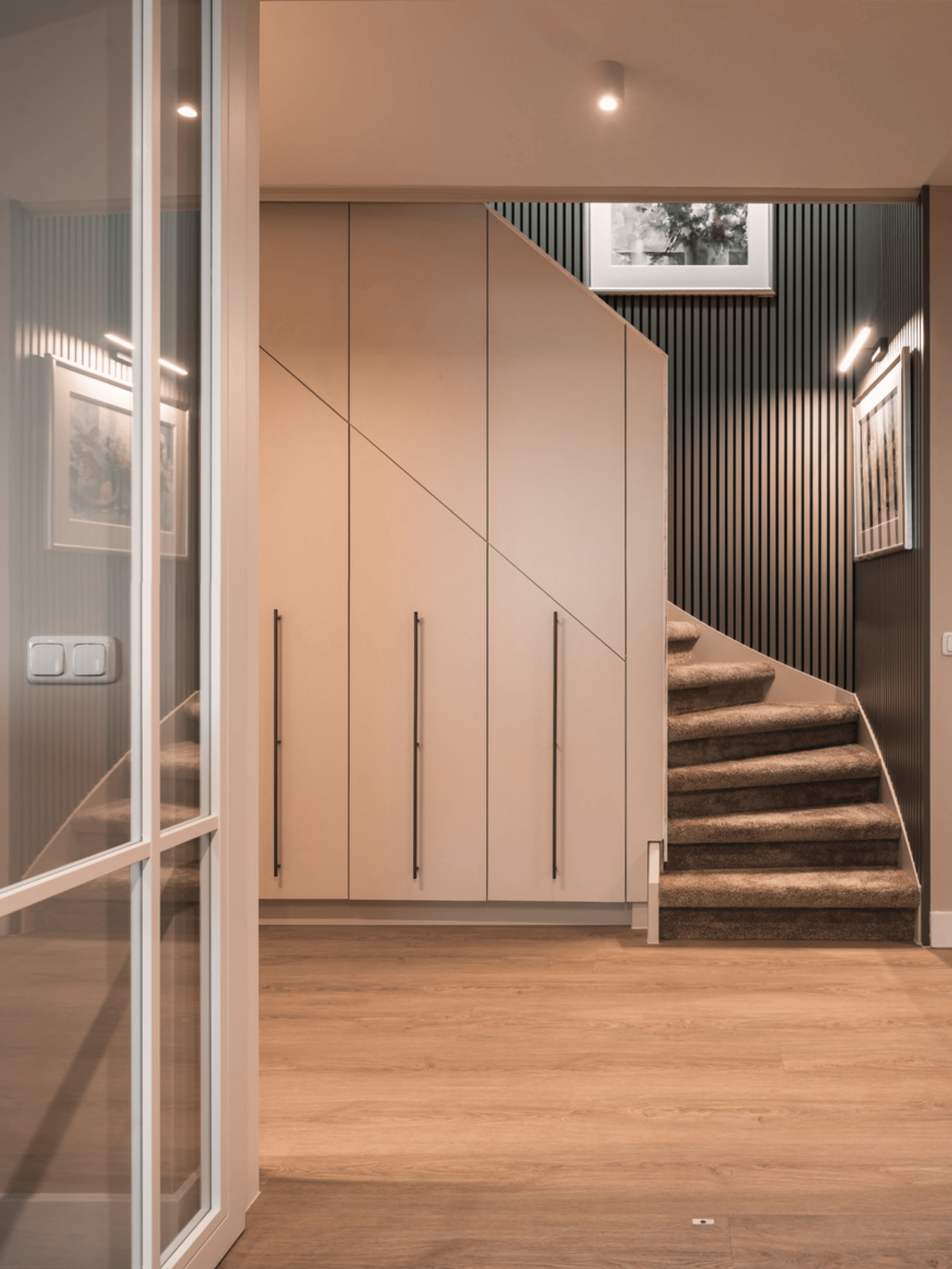 Strak landelijk interieur afgewerkt met verf van Pure & Original in zachte natuurtinten. Houten vloer zorgt voor warmte, gecombineerd met witte sierprofielen, grote schilderijen als eyecatcher en groene planten voor een natuurlijke uitstraling.