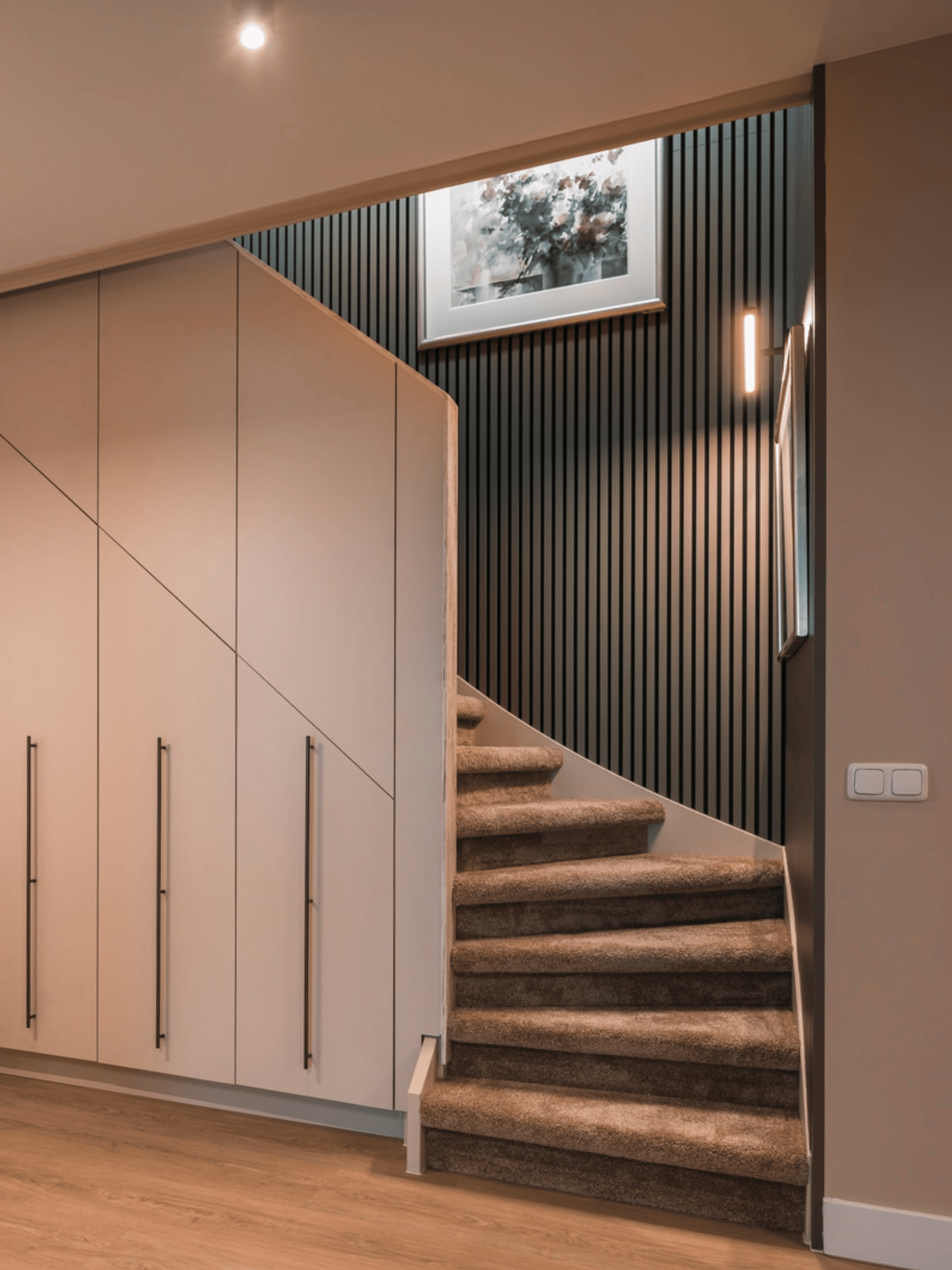 Strak landelijk interieur afgewerkt met verf van Pure & Original in zachte natuurtinten. Houten vloer zorgt voor warmte, gecombineerd met witte sierprofielen, grote schilderijen als eyecatcher en groene planten voor een natuurlijke uitstraling.