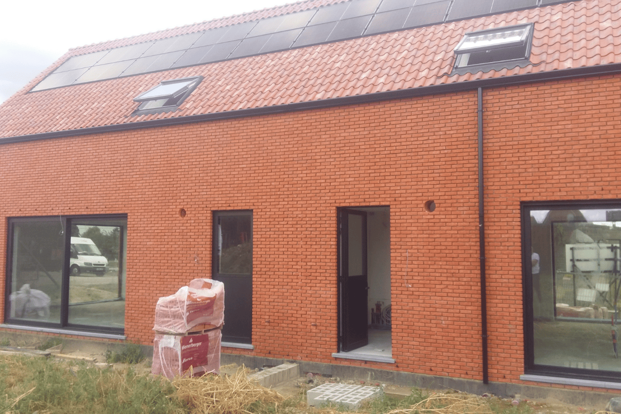 Moderne projectwoning met beige gekaleide gevel, houten gevelbekleding en oranje dakpannen. Duurzame gevelafwerking met een warme, landelijke uitstraling.