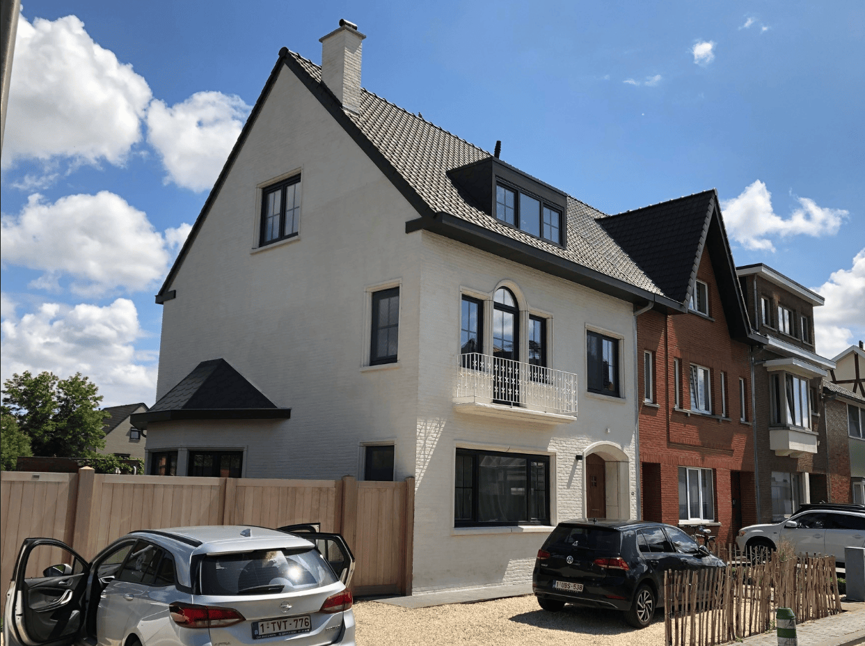 Na het kaleien: volledig gerenoveerde woning met beige gekaleide gevel, nieuwe zwarte aluminium ramen en een moderne, duurzame gevelafwerking met een landelijke uitstraling.