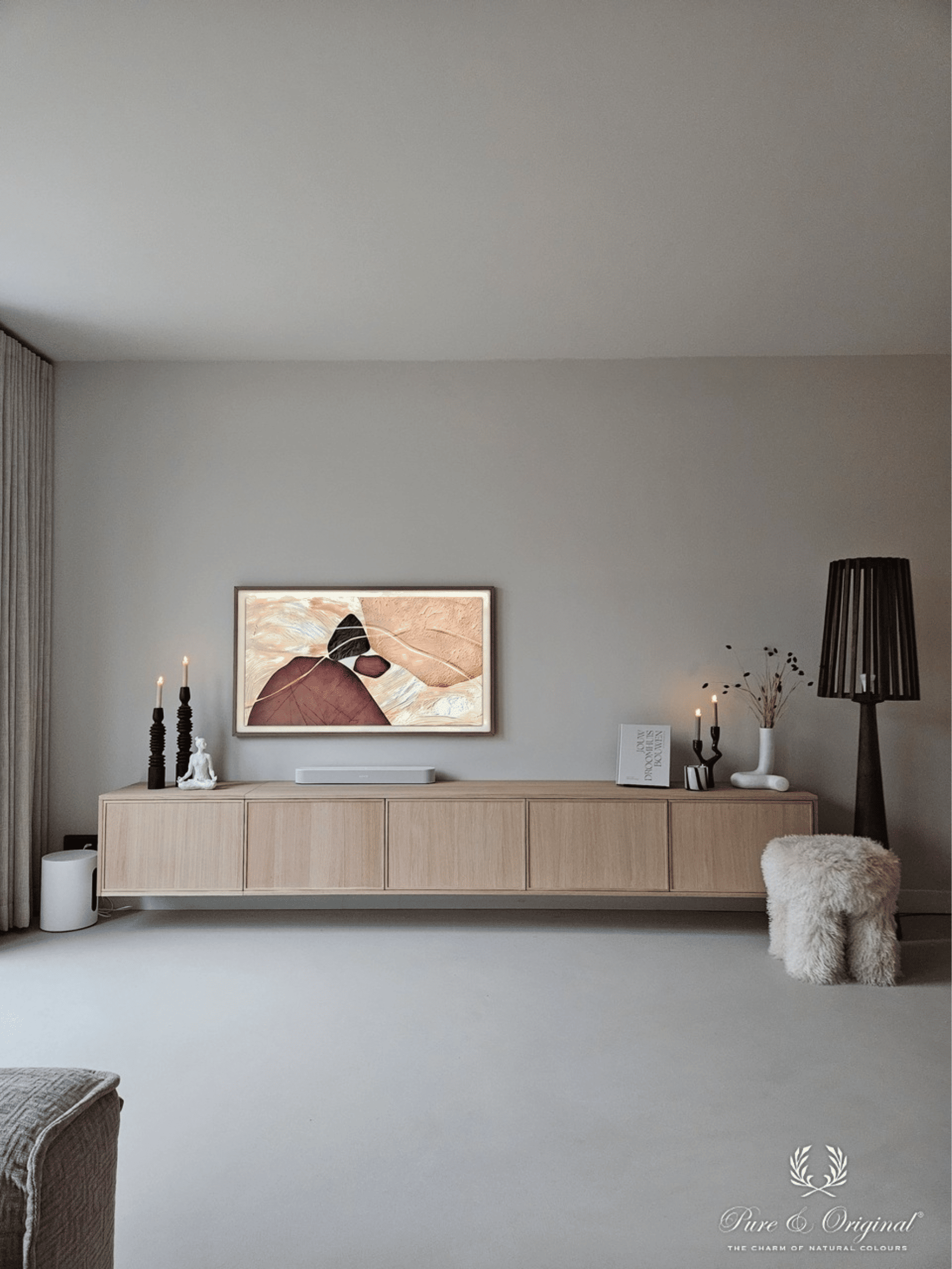 Interieur met warme grijze tinten op muren en plafond in verschillende nuances. Houten elementen brengen warmte en balans, gecombineerd met een opvallend kunstwerk met organische vormen in beige en terracotta tinten.