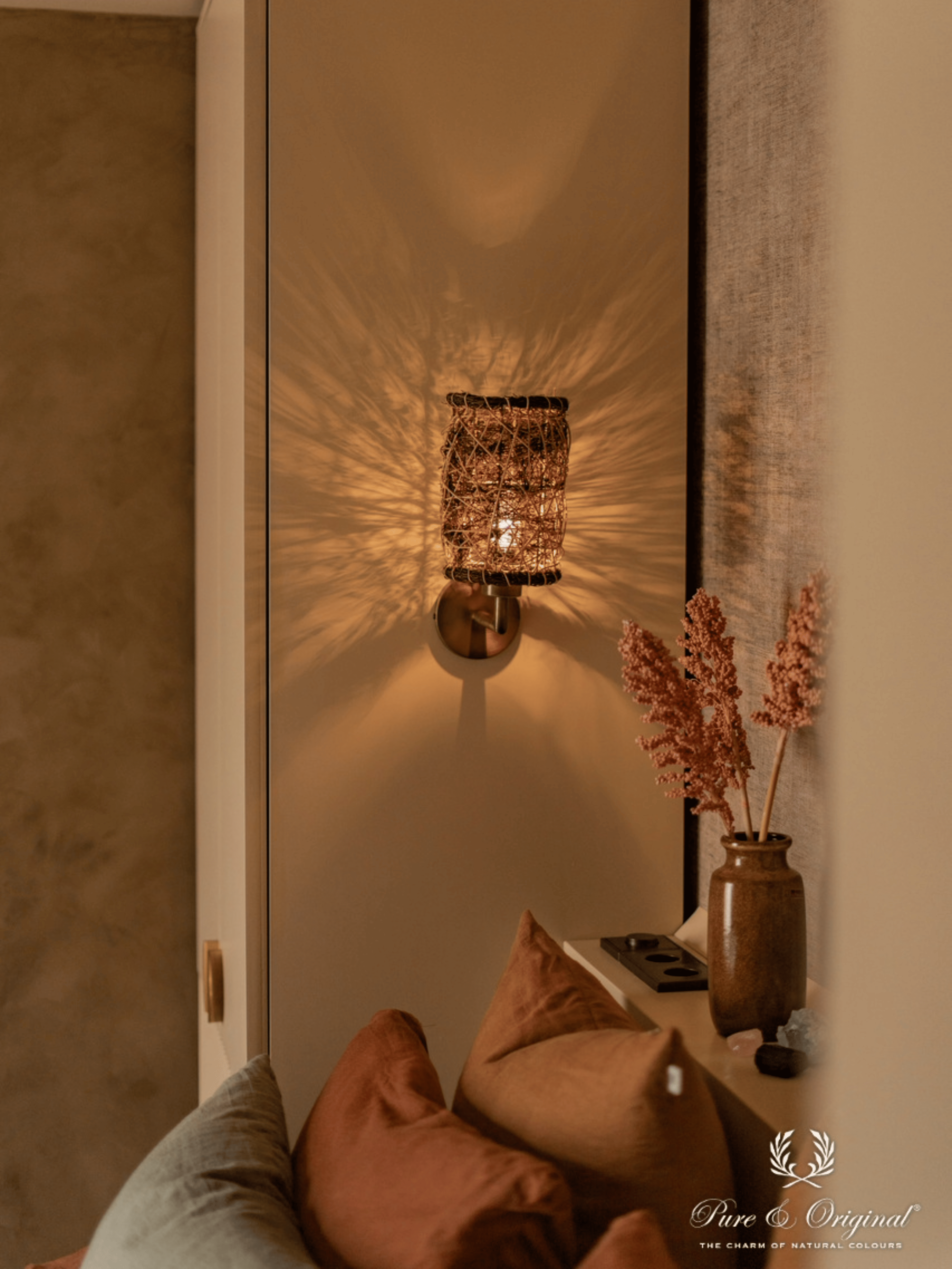 Interieur met een warme bruine decoratieve verftechniek op de muren, gecombineerd met Afrikaanse interieuraccenten en souvenirs uit wereldlanden. Sfeervolle slaapkamer en badkamer met natuurlijke materialen en een exotische, persoonlijke uitstraling.