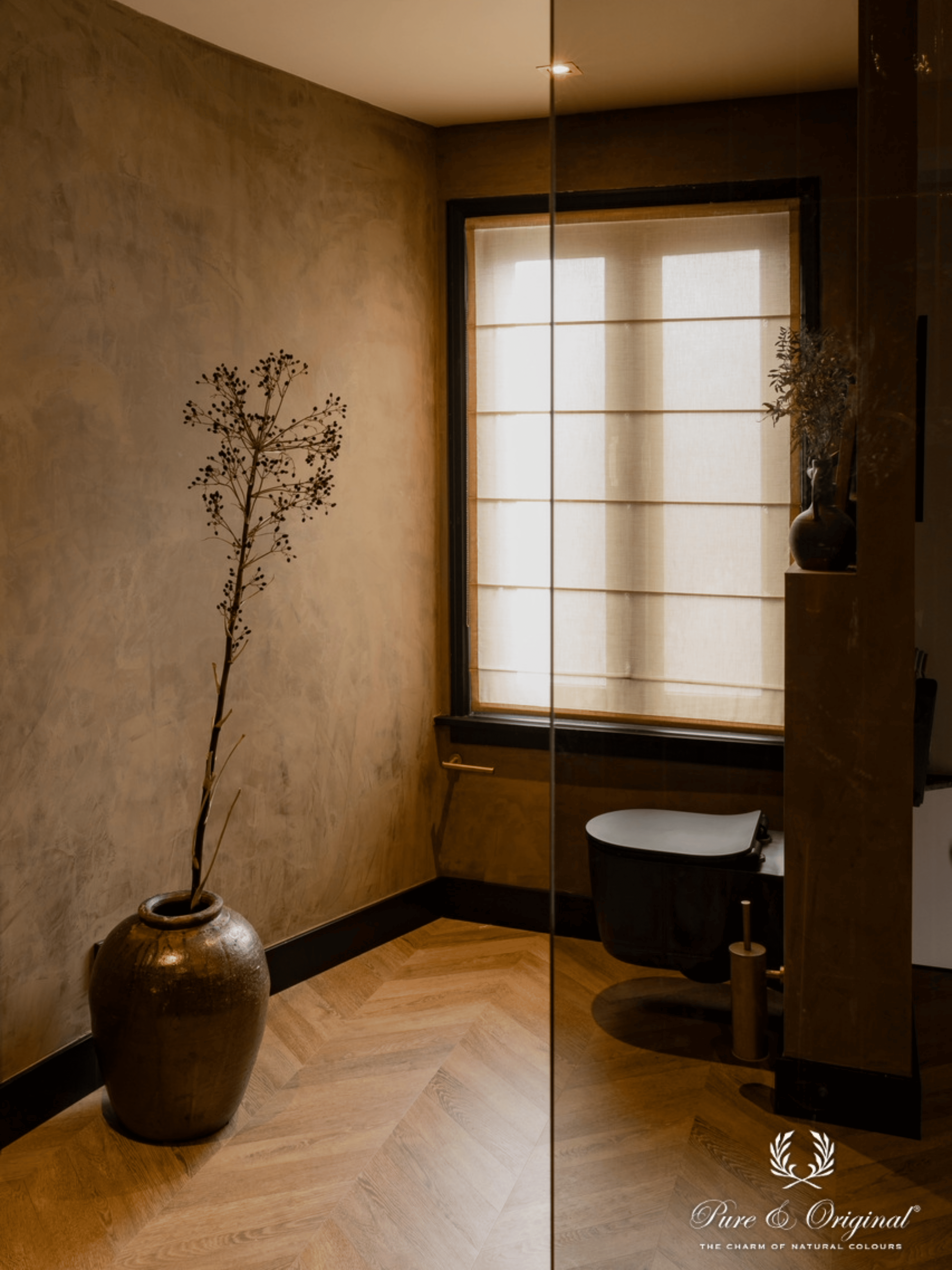 Interieur met een warme bruine decoratieve verftechniek op de muren, gecombineerd met Afrikaanse interieuraccenten en souvenirs uit wereldlanden. Sfeervolle slaapkamer en badkamer met natuurlijke materialen en een exotische, persoonlijke uitstraling.