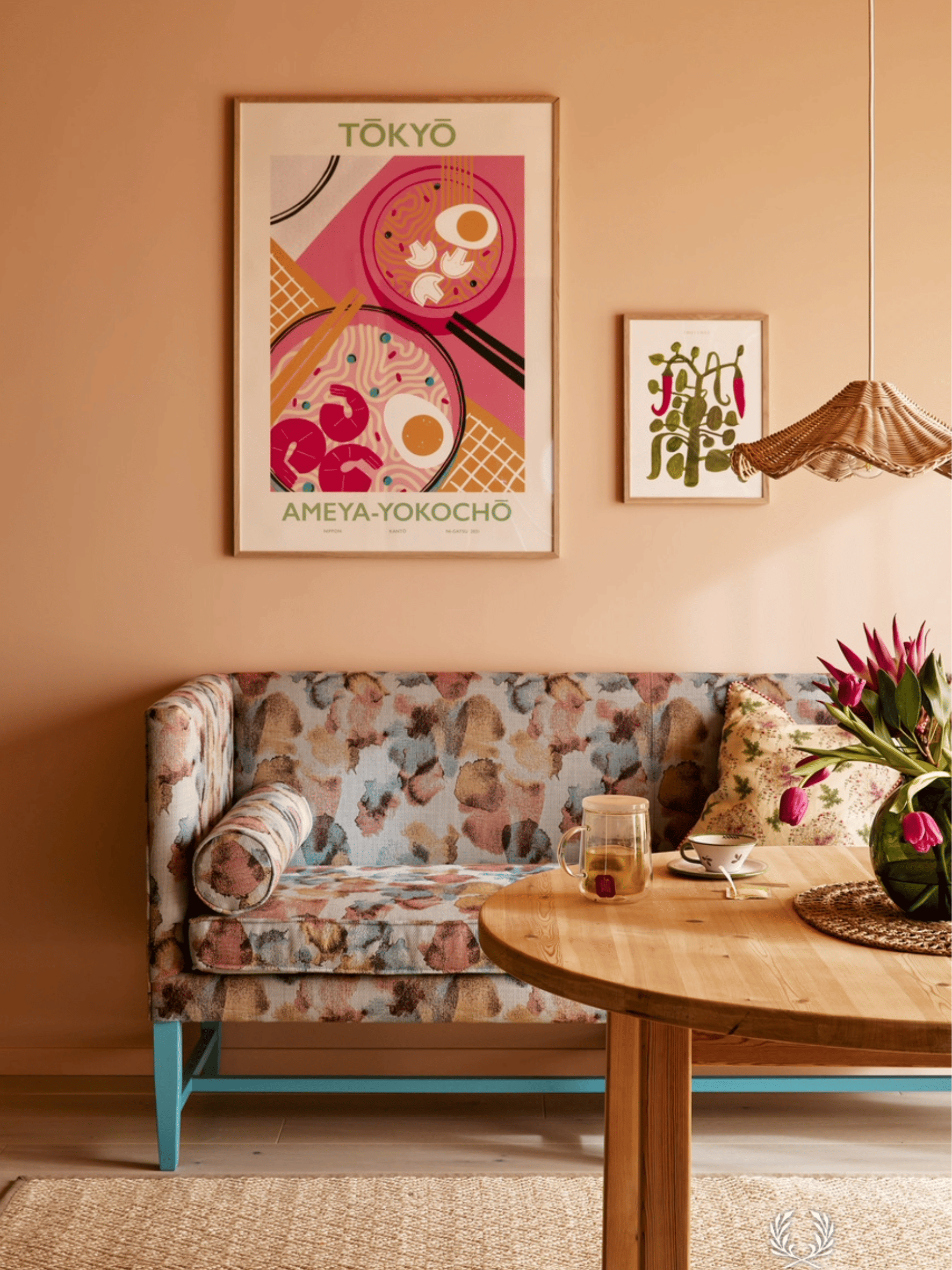 Interieur met prachtige coral kleurige verf in oranje tinten, gecombineerd met een zitbank met kleurrijk klassiek motief. Warme houten elementen en subtiele roze en blauwe accenten zorgen voor een levendig en stijlvol interieur.