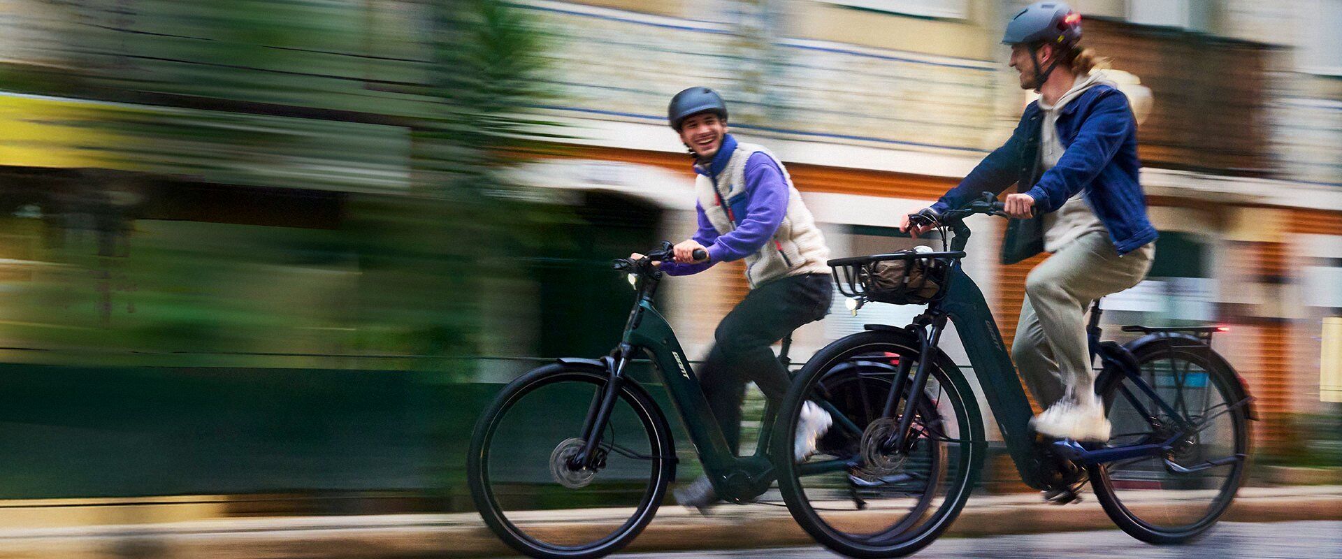 Deux cyclistes en ville sur des vélos électriques Giant NewTour E+