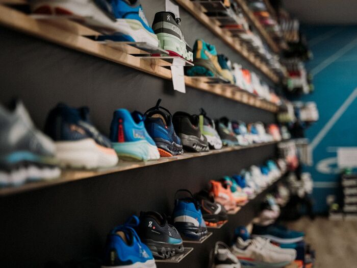 Mur de chaussures de running au magasin UrbanTriSports, recyclage Fast Feet Grinded